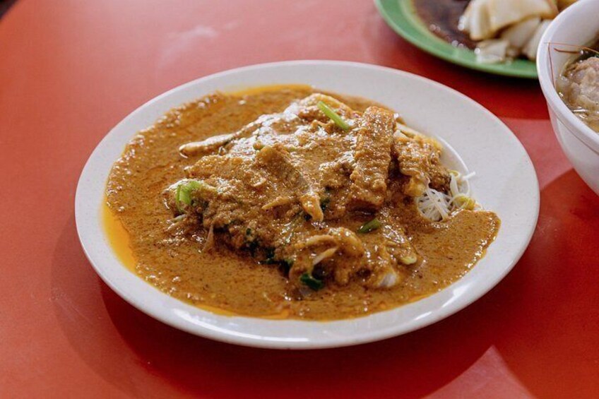 Un plato de curry con carne y verduras sobre una mesa roja. 4