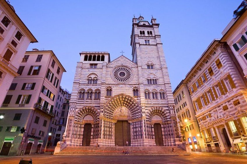 Una catedral histórica con un amplio ventanal circular, una entrada en arco y una alta torre campanario. 4
