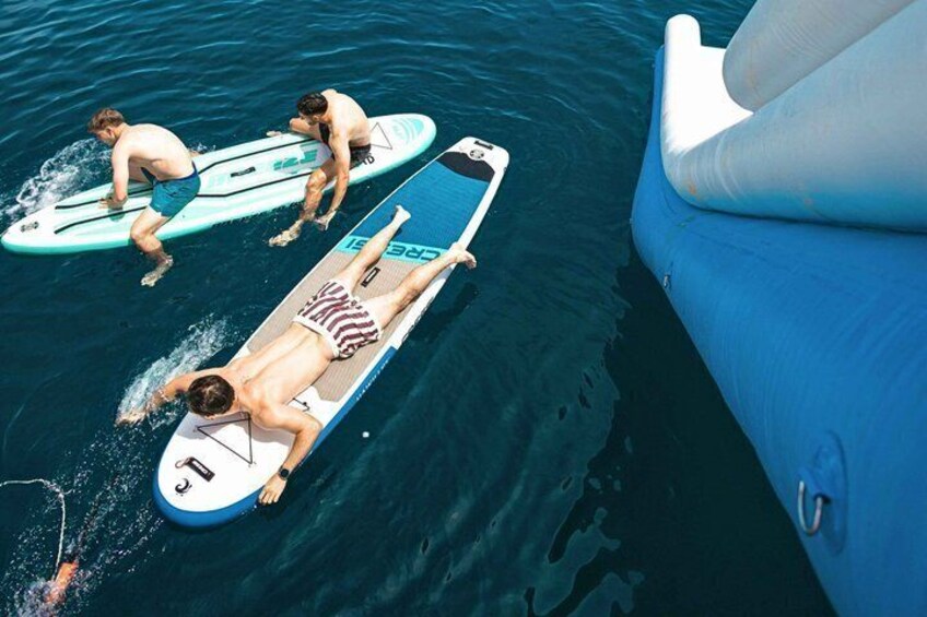 Des personnes sur des planches de surf dans l’eau, un bateau et une personne allongée sur une planche de surf. 5