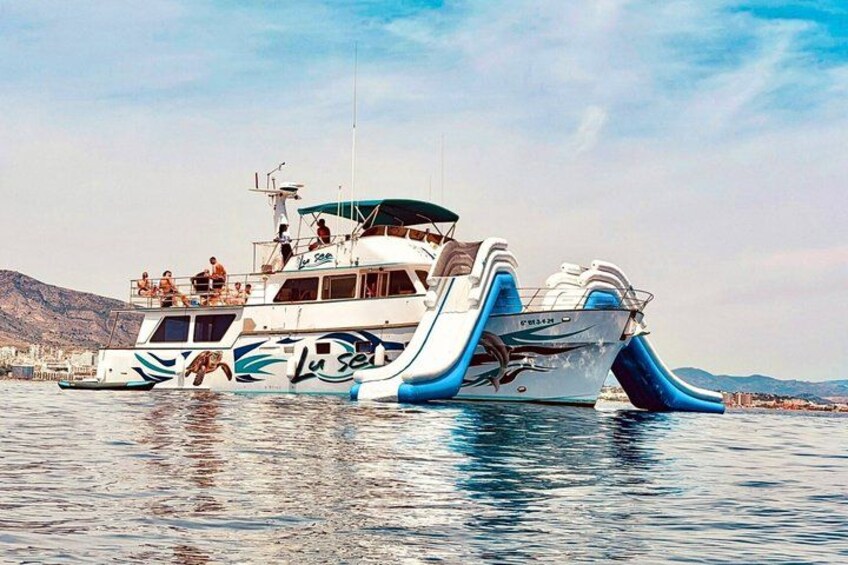 A large boat with a blue and white color scheme, a slide, and people on deck. 2