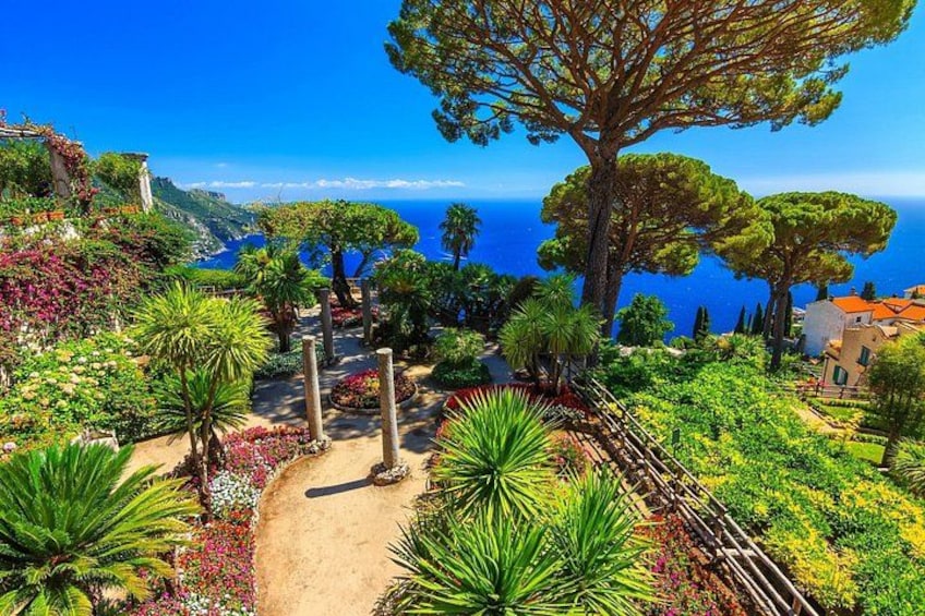 A coastal garden with pathways, trees, and a view of the sea. 2