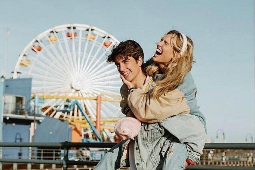 A person carrying another on their back with a Ferris wheel in the background. 1