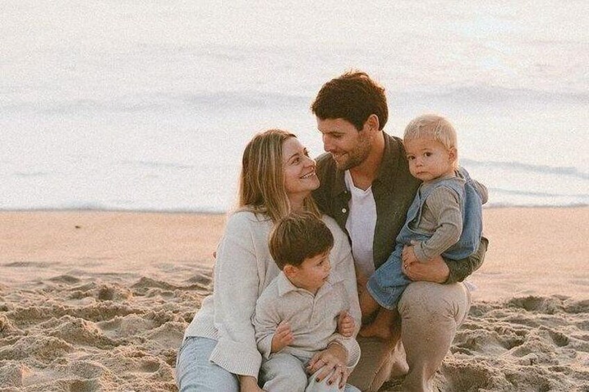 A family on a sandy beach with a calm sea in the background. 2