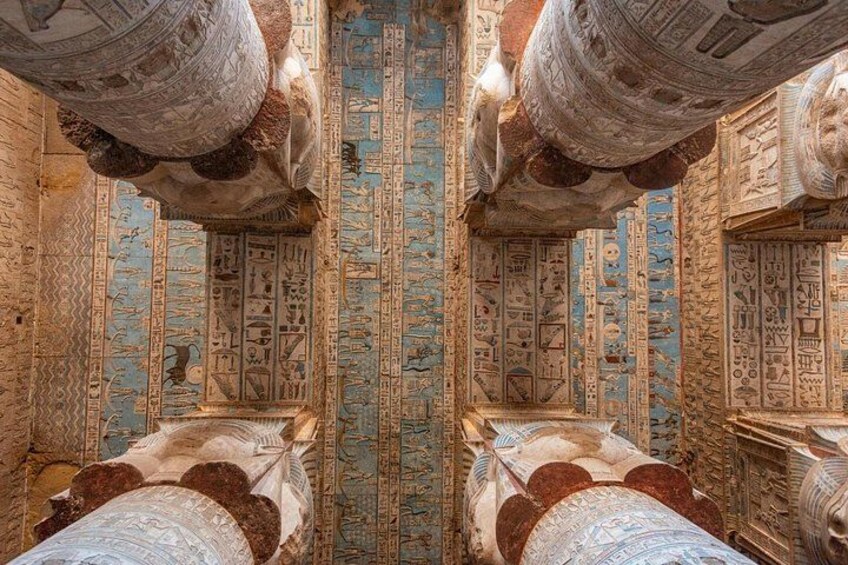 An ancient Egyptian tomb with hieroglyphs on the walls and ceiling, and a sarcophagus. 2