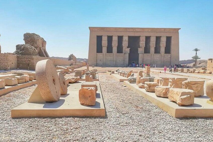Ancient Egyptian ruins with large stone blocks and a temple in the background. 3