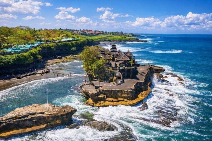A coastal temple complex on a rocky outcrop with waves crashing below. 1