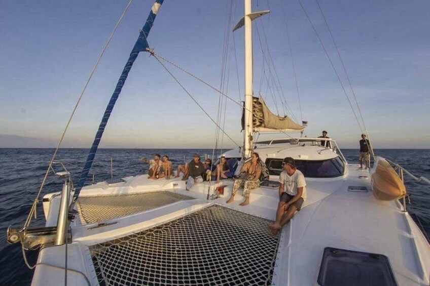 Een zeilboot met mensen op het dek, een heldere lucht en rustig water. 2