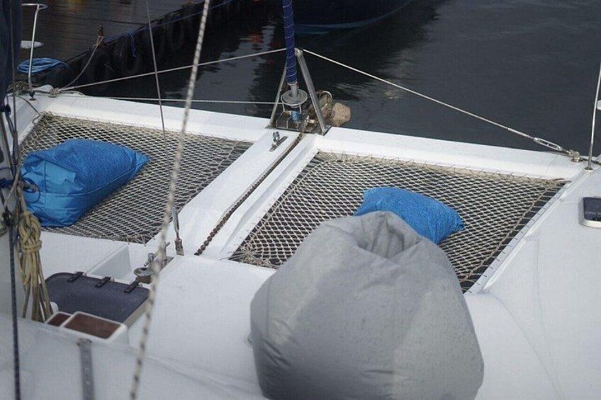 Ett båtdäck med två blå kuddar och en grå kudde. 2