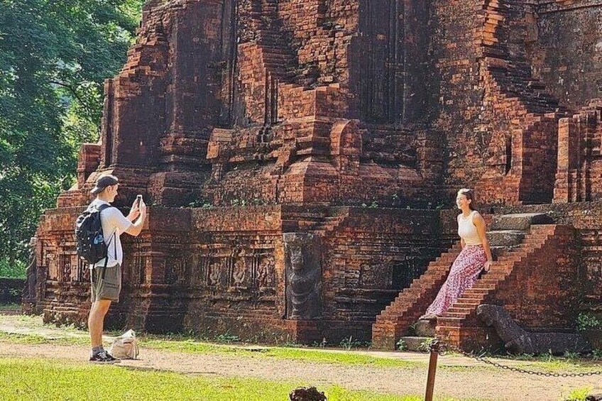 Une personne prend une photo d’une grande structure ancienne en briques, avec des marches menant à celle-ci. 5