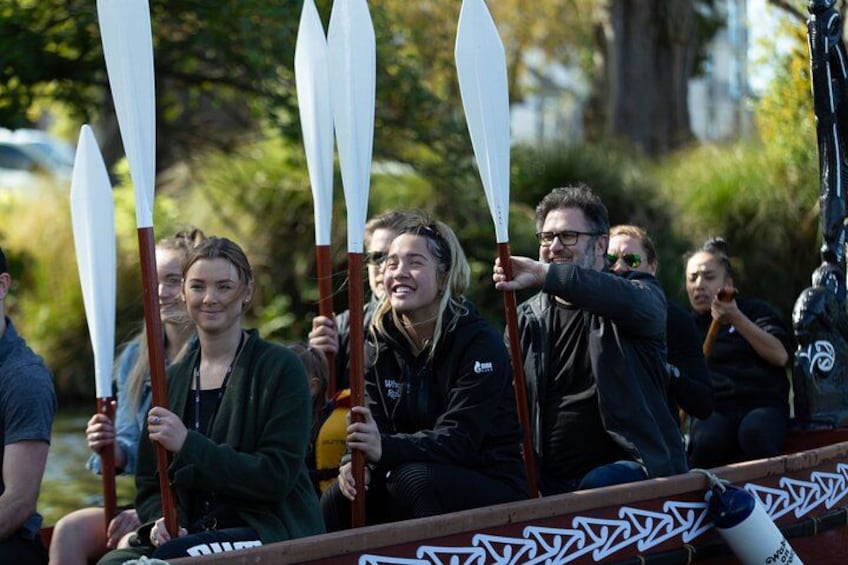 People in a boat holding paddles. 1