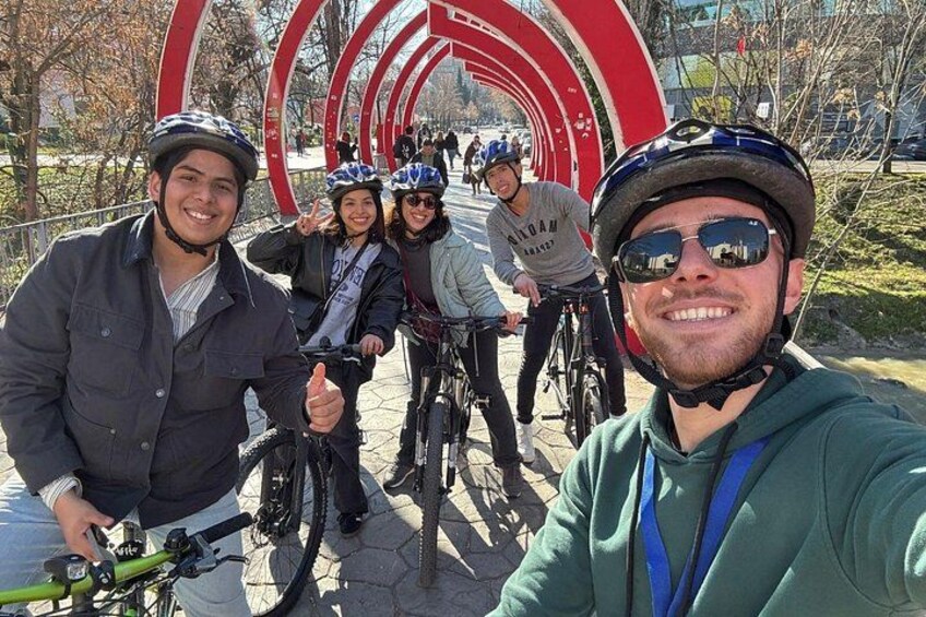 Un grupo de personas en bicicletas cerca de una gran estructura circular. 1