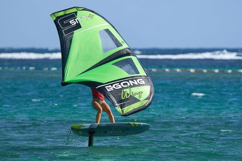 En person windsurfer på vandet med et grønt og sort sejl. 2