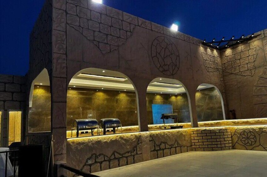 A stone building with arched windows and a seating area. 4