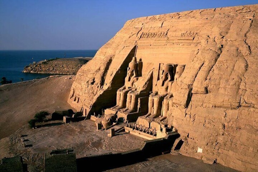 A large rock-cut temple with statues and hieroglyphs. 4