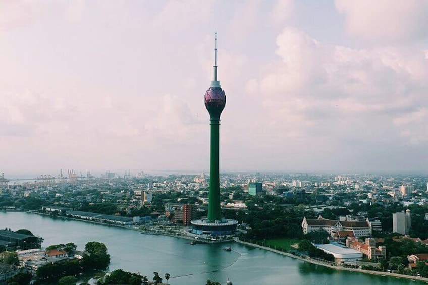 Een toren met een bolvormig uitkijkplatform, omringd door een rivier en stadsgezicht. 2