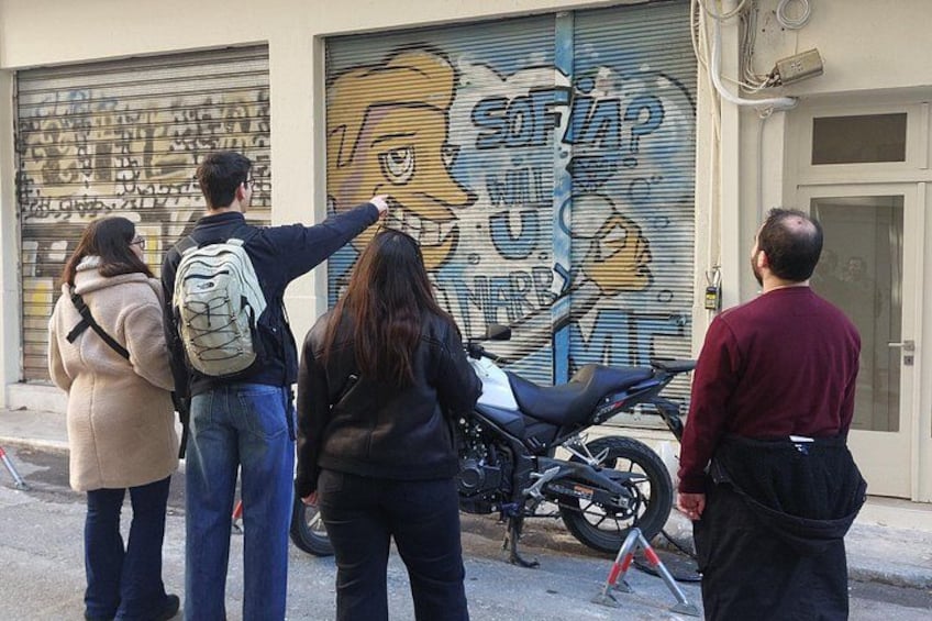 Un groupe de personnes se tient devant une fresque peinte sur une porte de garage. 1
