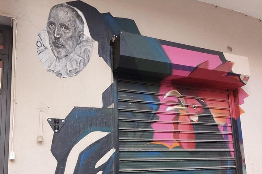 Un bâtiment orné d’une fresque représentant un visage et de graffitis colorés sur le volet. 5