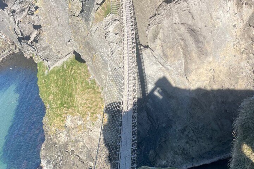 Eine Hängebrücke über unwegsames Gelände mit einem Gewässer an der Seite. 3