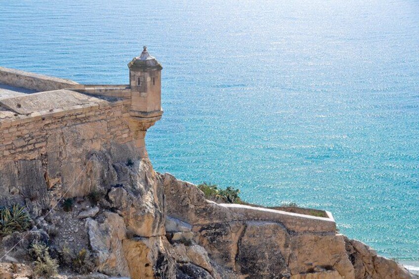 A coastal cliff with a lighthouse and a clear view of the sea. 2