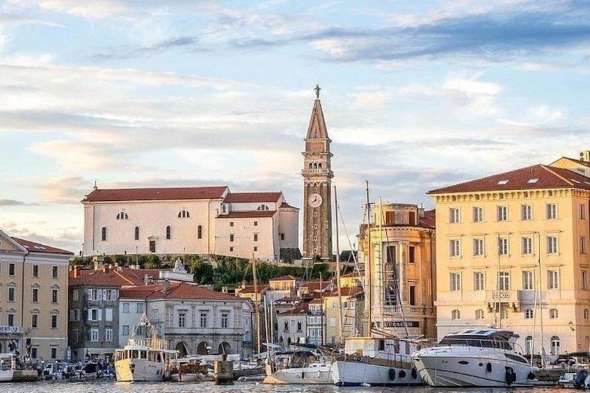 A harbor with boats, a clock tower, and historic buildings. 1