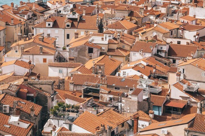 A densely packed urban area with closely built houses featuring red-tiled roofs and white walls. 3