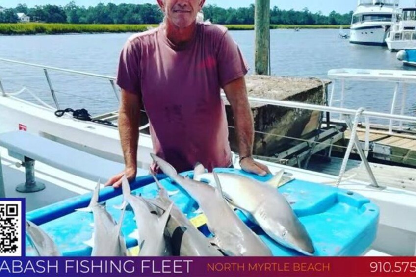 A man on a boat with several fish. 1
