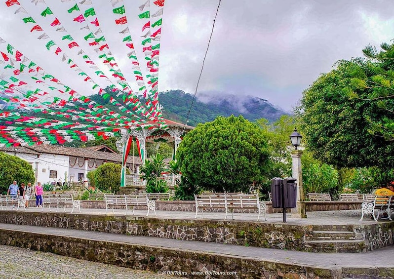 A plaza with a fountain, benches, and a mountain backdrop. 5