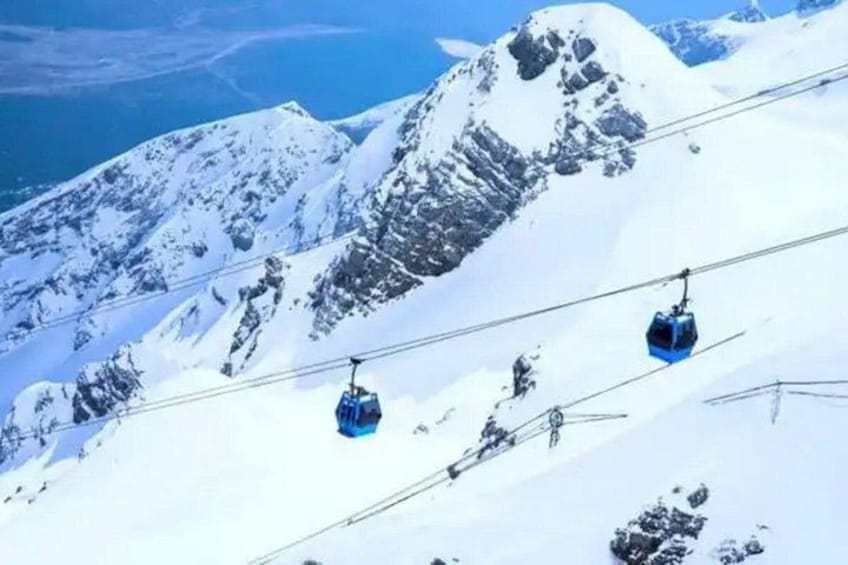 A snowy mountain with a cable car system. 1