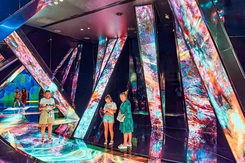 A modern indoor space with reflective surfaces and colorful light patterns. 2