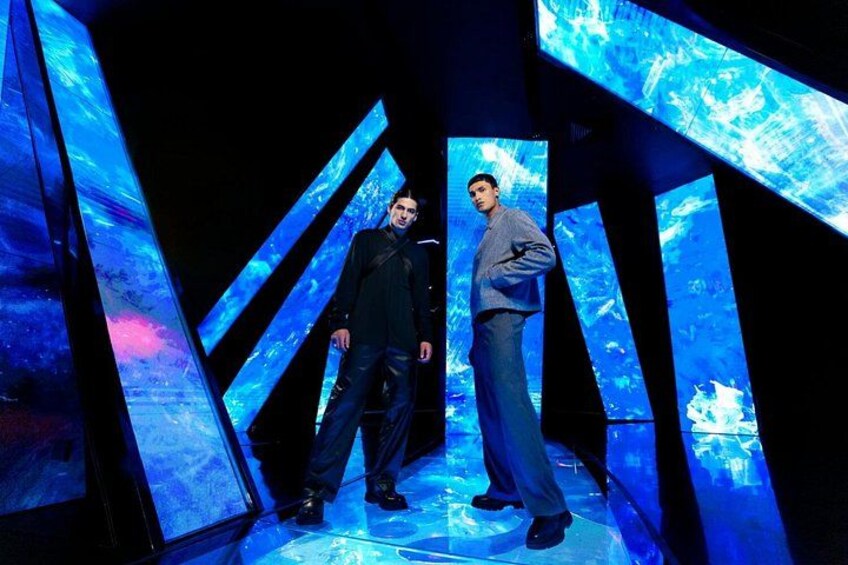 Two individuals in a futuristic setting with illuminated geometric structures. 5