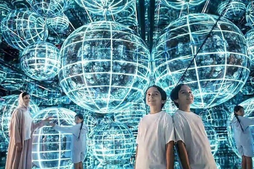 A group of people in white robes standing in front of a backdrop of illuminated spherical structures. 3