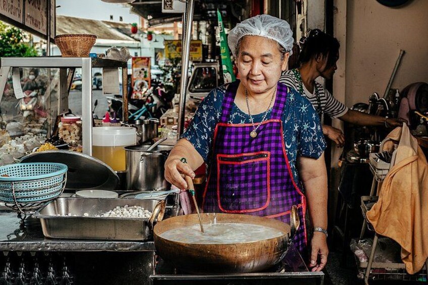 A street food vendor preparing food at a stall. 4