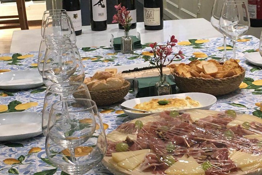 A table set with plates of food, wine glasses, and bottles of wine. 4