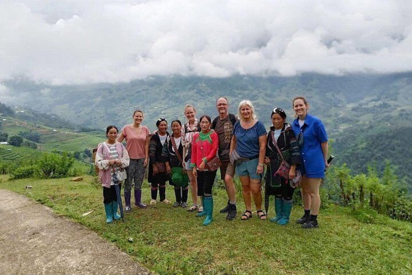 A group of people standing on a grassy hillside with a mountainous landscape in the background. 3