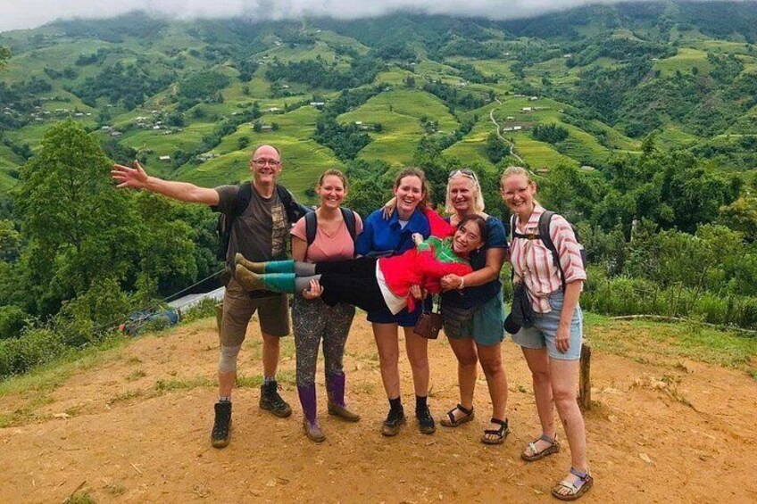 A group of people standing on a dirt path with a mountainous landscape in the background. 5