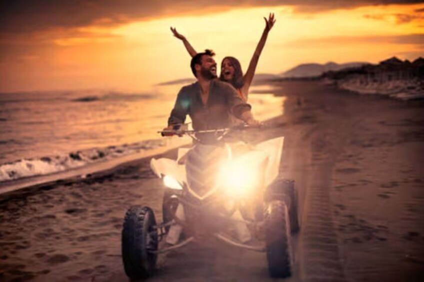 Une personne conduisant un quad sur une plage au coucher du soleil. 5