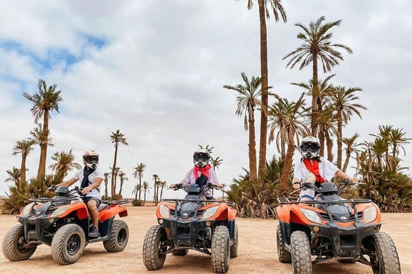 Tres personas paseando en cuatrimotos por un camino de tierra, con palmeras al fondo. 4