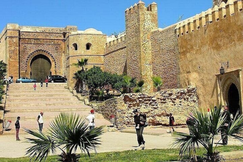 Una fortaleza histórica con un gran arco, una torre y una escalera que conduce a la entrada. 2
