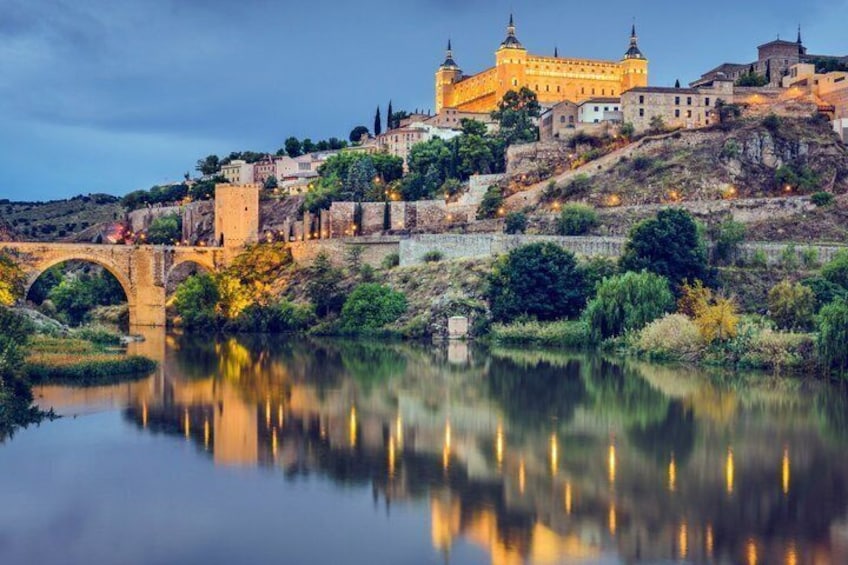 Un castillo histórico en una colina con vistas a un río tranquilo y un puente. 5