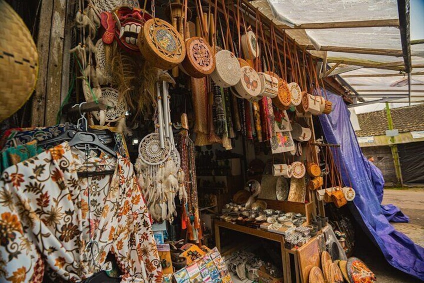 Un étal de marché proposant divers articles faits à la main, notamment des paniers tressés et des tissus décoratifs. 5