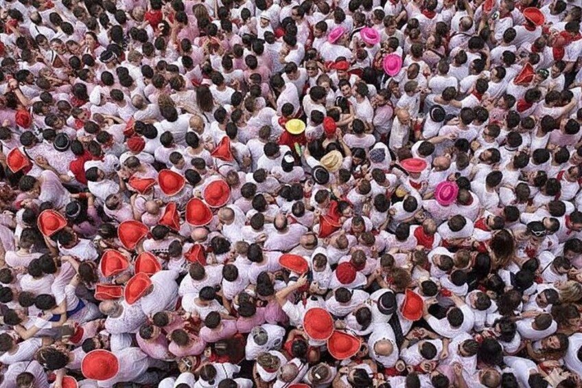 Una folla numerosa di persone vestite di bianco e rosso, raggruppate da vicino. 5