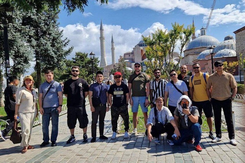 A group of people posing in front of a historical building with minarets. 2