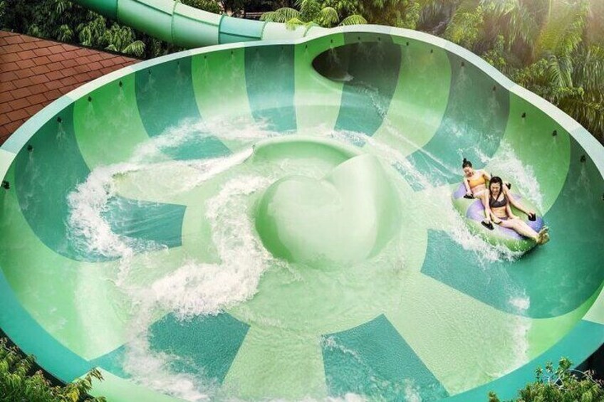 A water slide with two people riding inflatable tubes. 5