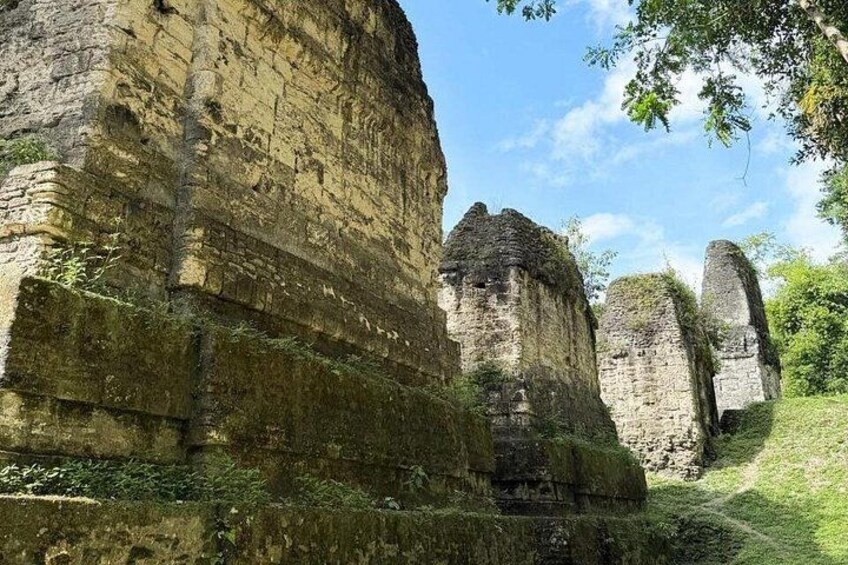 Ancient ruins with layered stone walls and a grassy path. 1