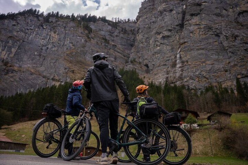 Una persona de pie entre dos bicicletas con mochilas, contemplando un paisaje montañoso. 3