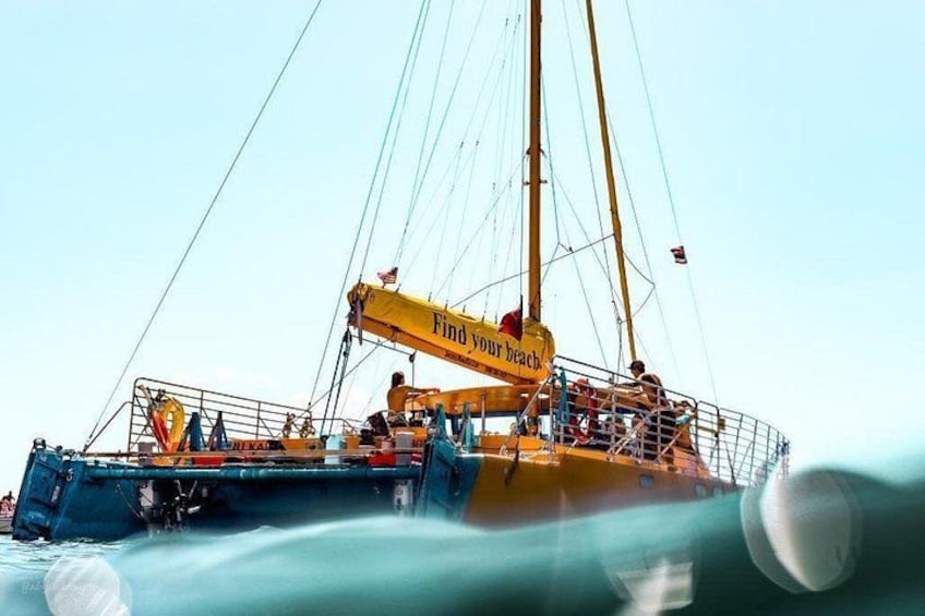 A large yellow boat with the text 'Find Your Beach' on its side, floating on water. 5