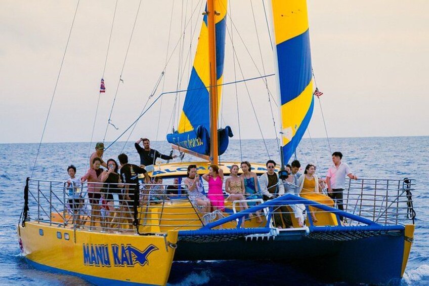 A yellow and blue sailboat with people on board. 4