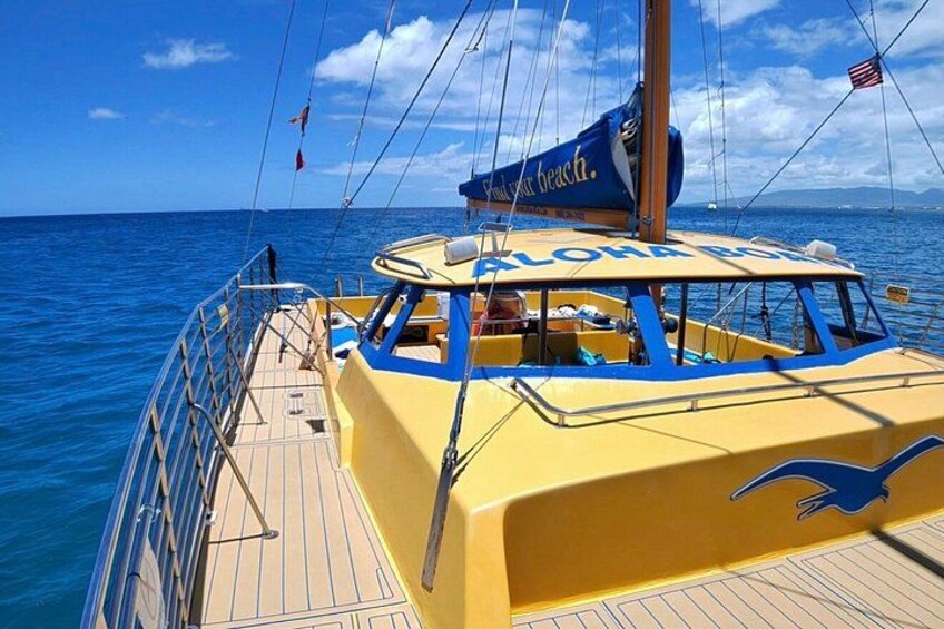 Una barca gialla con la scritta 'ALOHA BEACH' sul fianco, che naviga su acque blu. 3