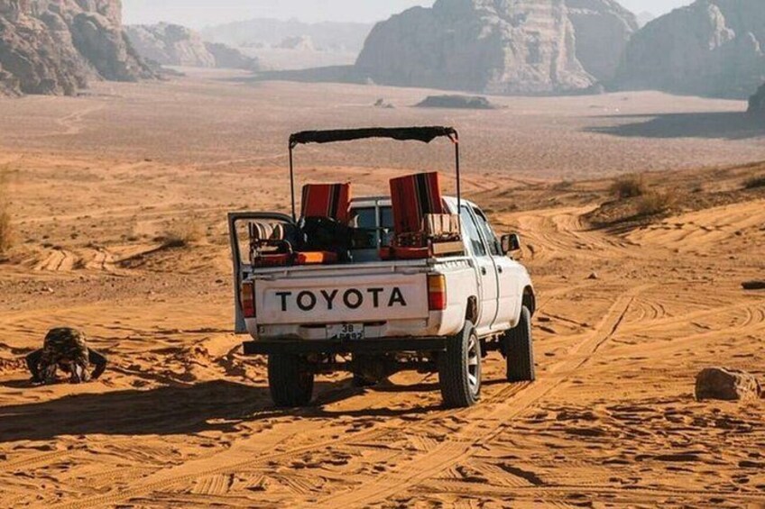 Una camioneta Toyota blanca en un desierto con un paisaje rocoso al fondo. 2