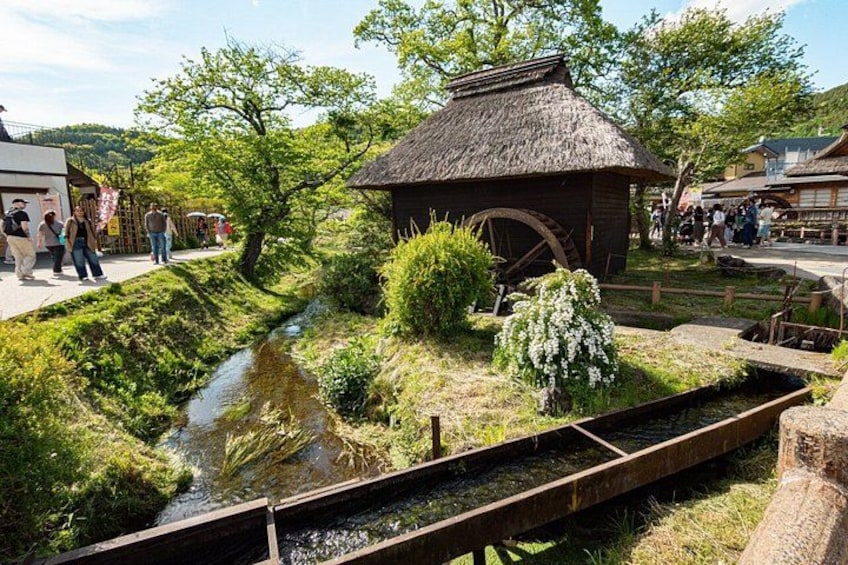 A traditional watermill, a small stream, and a wooden bridge. 5